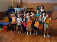 Dzieci wraz z nauczycielami stoją w grupie i pozują do zdjęcia