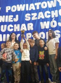 Zdjęcie grupy uczniów odbierających puchar za zajęcie drugiego miejsca w turnieju szachowym.