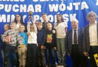 Zdjęcie grupy uczniów odbierających puchar za zajęcie drugiego miejsca w turnieju szachowym.