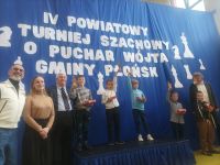 Dzieci na podium odbierający medale za zwycięstwo w turnieju szachowym.